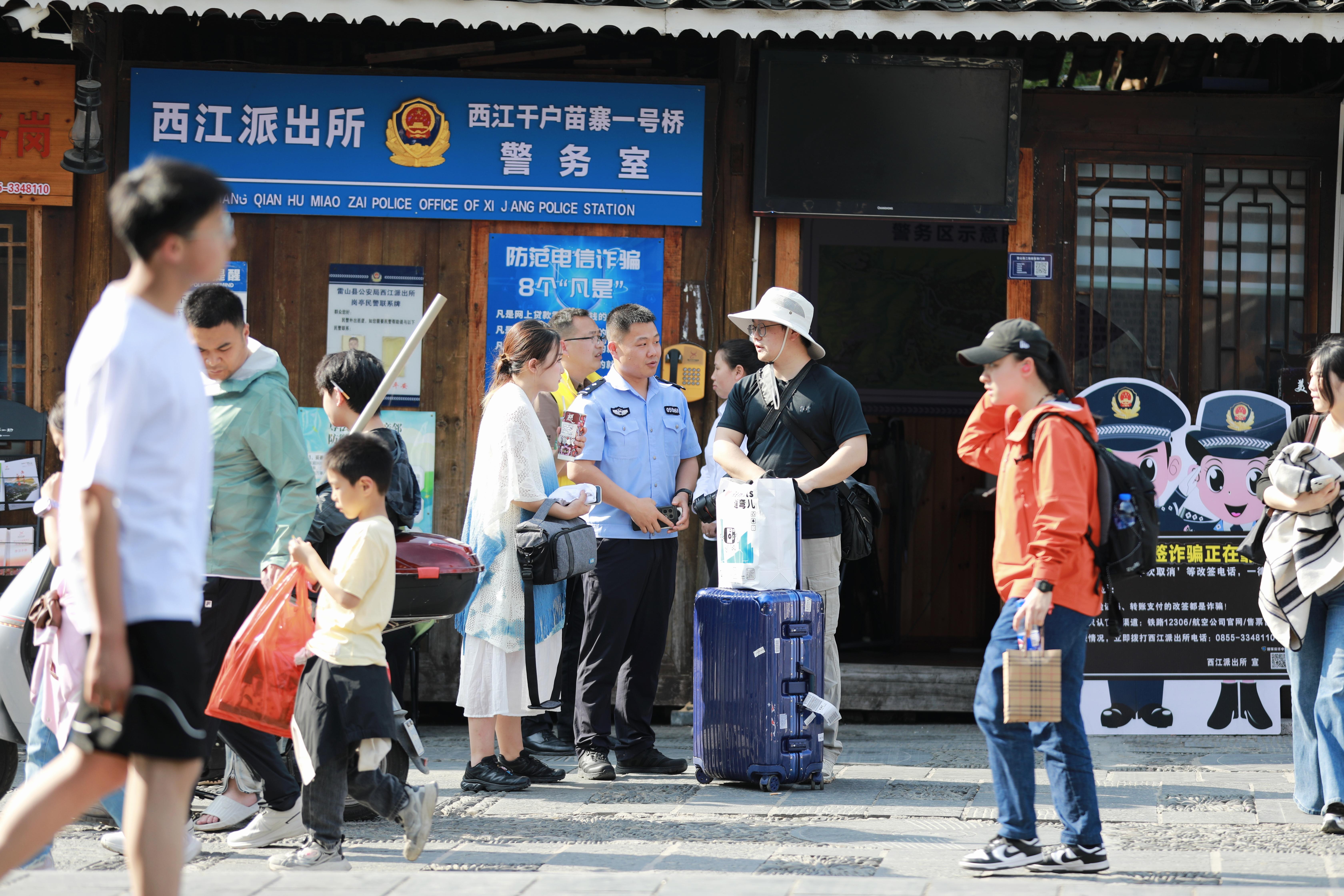 图2雷山县公安局西江派出所民警为游客提供咨询服务.jpg 图2雷山县公安局西江派出所民警为游客提供咨询服务.jpg